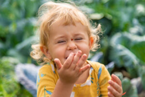 image of a giggling little girl with a ladybug on her nose